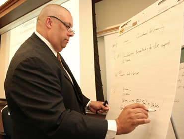 A professional maps out the markerboard with strategic plan information