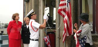 Freeholder Director Barbara McMorrow and Freeholder Lillian Burry look on as John Alexander Van Dyck raises a new flag over the county's Rumson - Sea Bright Bridge
