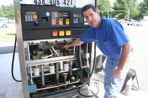 The Monmouth County Department of Weights and Measures is inspecting gasoline pumps at all 215 service stations in Monmouth County. Pictured above is Assistant Superintendent James Heath, who is checking the inner workings of one pump to make sure it has not been tampered with.