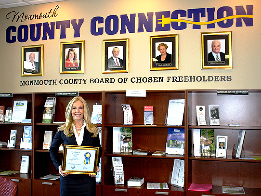 o Monmouth County Clerk Christine Giordano Hanlon holds the Certificate of Excellence awarded to the Monmouth County Connection by the U.S. Department of State for its excellent passport services.