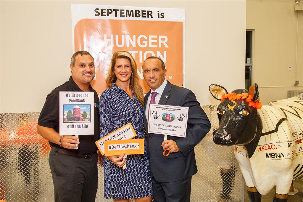 FoodBank of Monmouth and Ocean Counties Executive Director Carlos Rodriguez, Freeholder Deputy Director Serena DiMaso and Freeholder Director Thomas A. Arnone participate in Hunger Action Family Day at the FoodBank on Sept. 1 in Neptune, NJ.